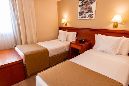 a hotel room with two beds and a window at Hotel Riviera in Mar del Plata