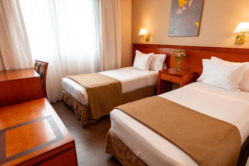a hotel room with two beds and a window at Hotel Riviera in Mar del Plata