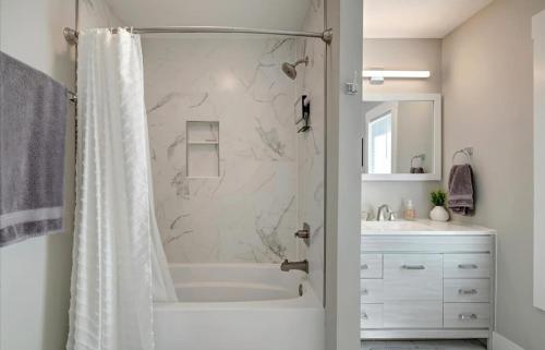 a bathroom with a shower and a tub and a sink at Bloomington Bliss in Bloomington