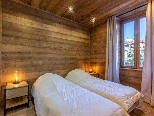a bed in a room with a wooden wall at Appartement La Clusaz, 4 pièces, 8 personnes - FR-1-437-71 in La Clusaz