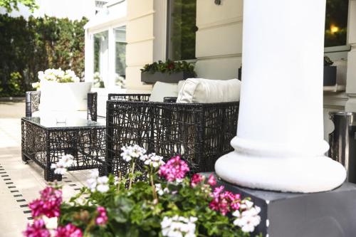 a porch with chairs and flowers and a column at Hotel Marienthal Garni in Hamburg