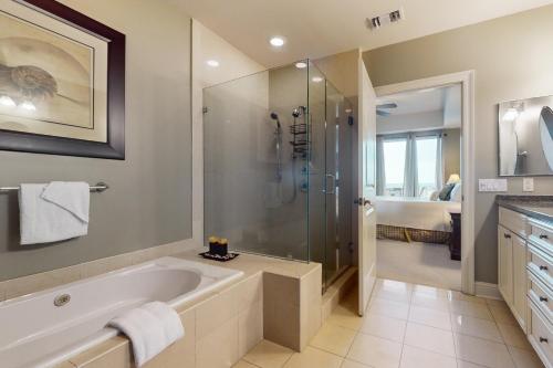 een badkamer met een groot bad en een douche bij The Wharf in Orange Beach