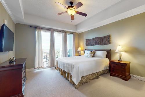 a bedroom with a bed and a ceiling fan at The Wharf in Orange Beach