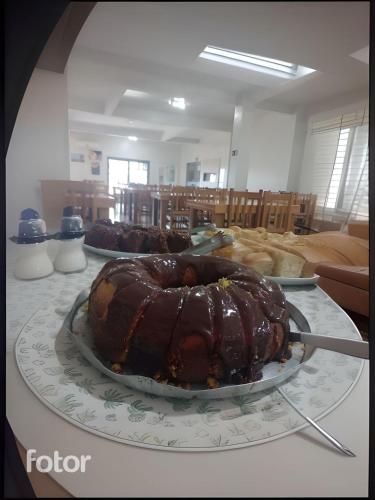 een cake op een bord op een tafel met andere zoete deegwaren bij Pousada Sol e Praia in Torres