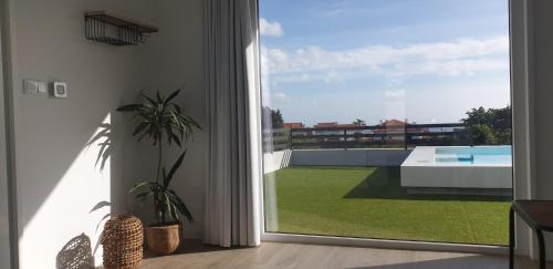 a living room with a sliding glass door to a yard at One of a Kind #PDL Luxury Retreat in Ponta Delgada