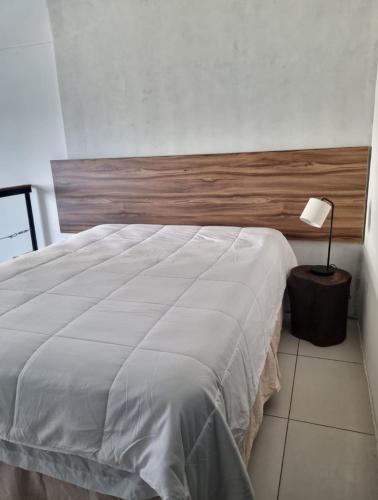 Un dormitorio con una gran cama blanca y una lámpara en Apartamento tipo Loft, en Guatemala