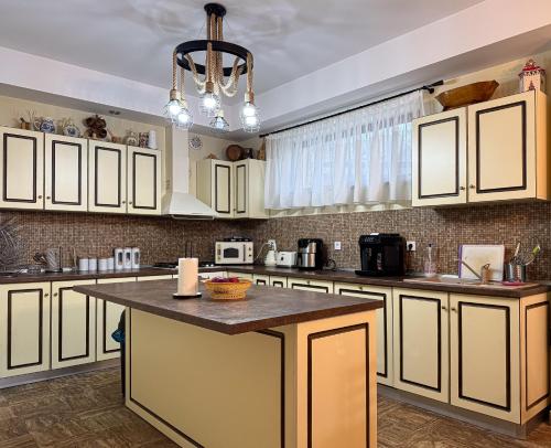 a kitchen with white cabinets and a large island at Transylvanian Views in Peştera