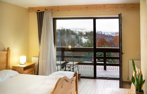 a bedroom with a bed and a large window at Transylvanian Views in Peştera