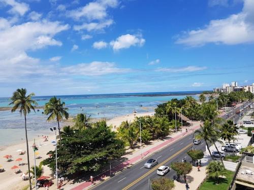 uma vista para uma praia com palmeiras e para o oceano em Apart Ponta Verde em Maceió