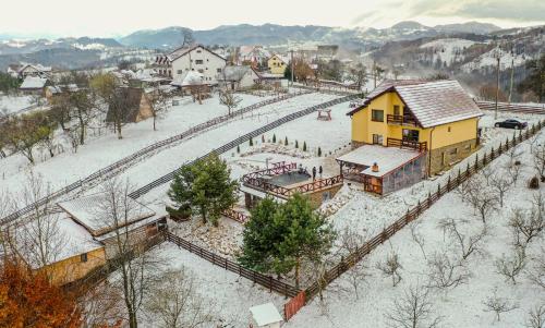 a town with a train station in the snow at Transylvanian Views in Peştera