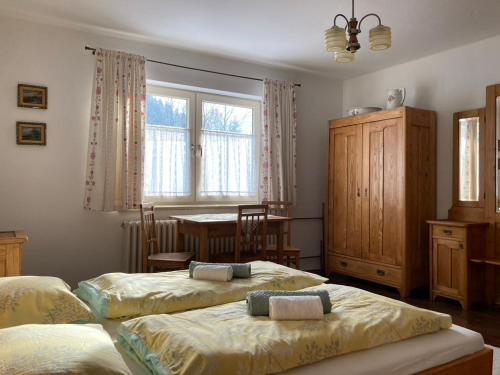 a bedroom with two beds and a table and a window at Chalupa Barbolica in Vernár