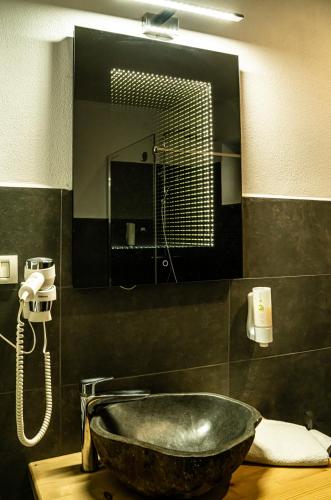 a bathroom with a stone sink and a mirror at Transylvanian Views in Peştera