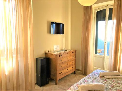 a bedroom with a dresser and a television on the wall at Villa Silvana in Perledo