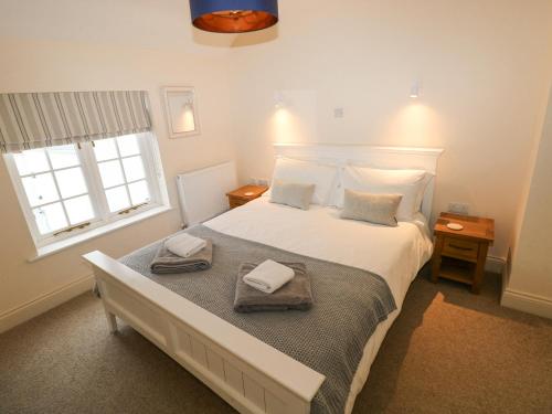 a bedroom with a large bed with towels on it at The Old Boathouse in Haverfordwest