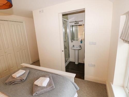 a bedroom with a bed and a sink and a mirror at The Old Boathouse in Haverfordwest