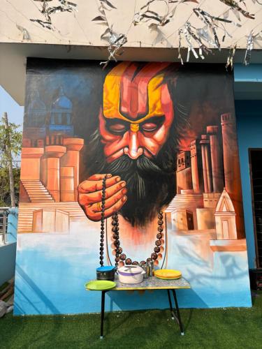 Un grande dipinto di un uomo su un muro di Gully Ghar a Varanasi