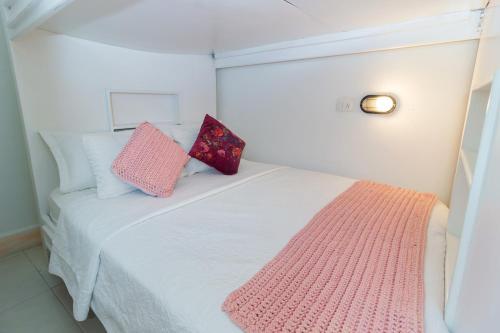 a bedroom with a bed with two pillows on it at Voilá Signature Casa Isabel in Cartagena de Indias