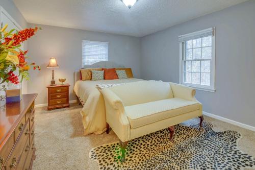 um quarto com uma cama, uma cadeira e janelas em Charming Tennessee Retreat with Fireplace and Grill! em Jackson