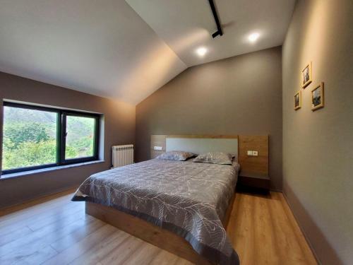 a bedroom with a bed and a large window at Lady and Bear GH in Sǝrdakhar
