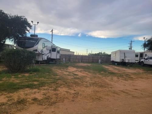 a train parked next to a fence with a trailer at Cotulla Whitten Inn in Cotulla