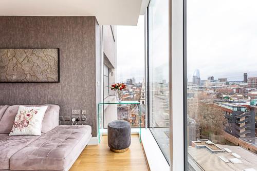 a living room with a couch and a large window at Stunning London View Flat in London