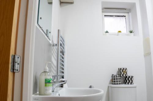 a bathroom with a sink and a window at Modern Two Bedroom Apartment with Free Parking, Wifi & Sky TV by HP Accommodation in Milton Keynes