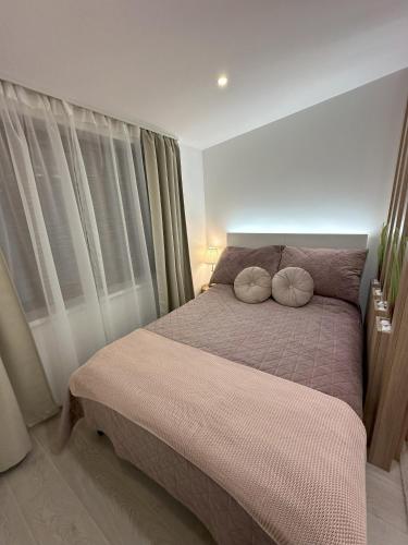 a bedroom with a bed with two pillows on it at Dux Apartmani - Milmari, Kopaonik in Cajetina