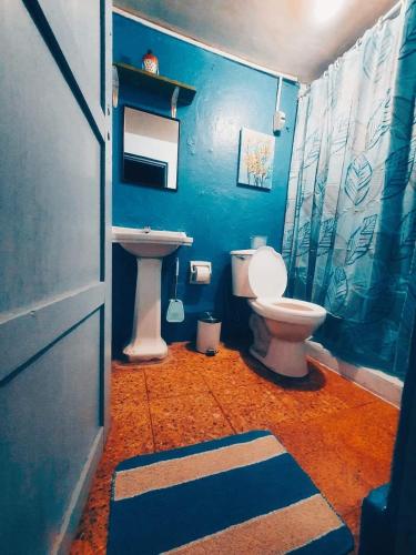 uma casa de banho azul com um WC e um lavatório em Ttikay Wasi em Cusco