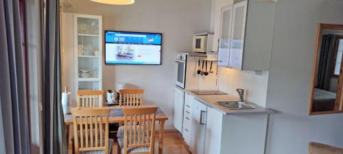a kitchen with a table and a tv on the wall at Apartments Tahko in Tahkovuori