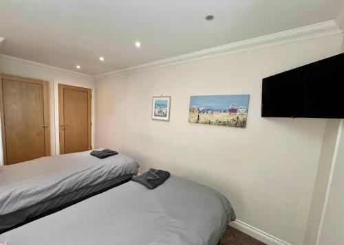 a bedroom with two beds and a flat screen tv at The Coastal Escape in Bournemouth