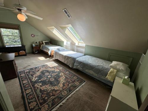 - une chambre mansardée avec 2 lits et un tapis dans l'établissement Large Home with Pool & 7 bedrooms; sleeps 21, à Severn