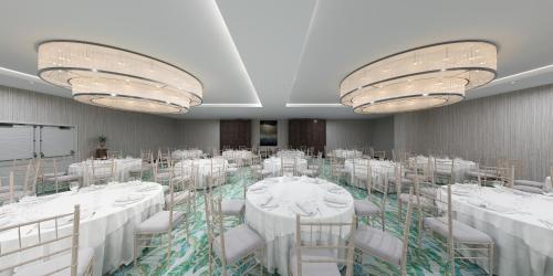 a banquet room with white tables and chairs and chandeliers at Margaritaville Beach Resort Ft Myers Beach in Fort Myers Beach