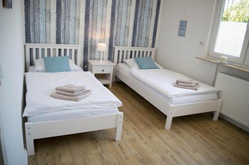 two beds in a small room with towels on them at Deichkind im Deichhaus in Husum