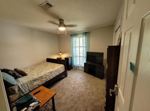 a bedroom with a bed and a flat screen tv at Bedroom Four minutes from beach in Pensacola