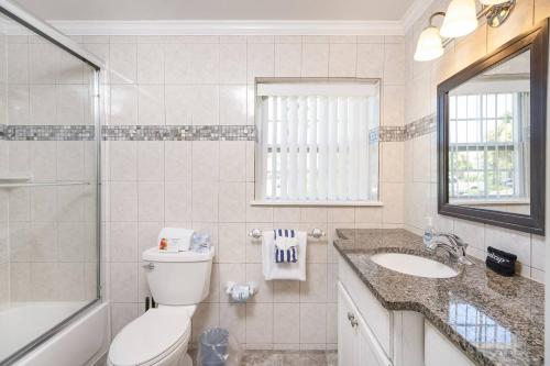 ein Bad mit einem WC, einem Waschbecken und einer Dusche in der Unterkunft Oceans 13 Unit A in Saint Augustine Beach