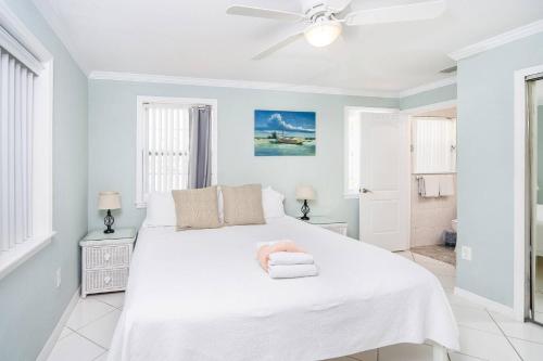um quarto branco com uma cama com um bicho de peluche cor-de-rosa em Oceans 13 Unit A em Saint Augustine Beach