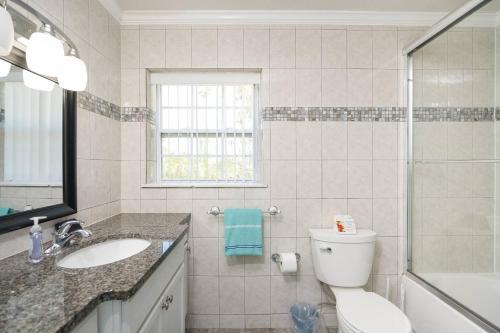 La salle de bains est pourvue de toilettes, d'un lavabo et d'une douche. dans l'établissement Oceans 13 Unit B, à Saint Augustine