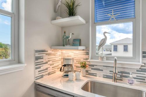 um balcão de cozinha com um lavatório e uma janela em Oceans 13 Condo C em Saint Augustine Beach