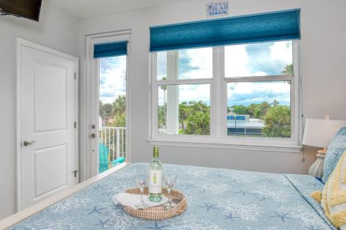 a bedroom with a bed with a bottle of wine at Oceans 13 Condo C in Saint Augustine Beach