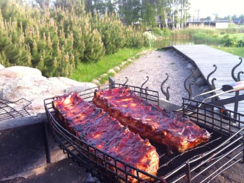 a row of ribs being cooked on a grill at Vila Ambasada in Šventoji