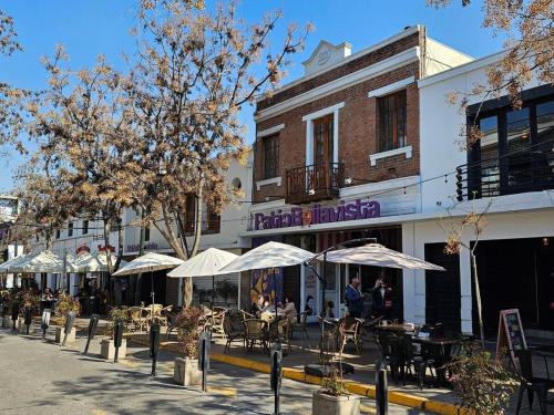 een straat met tafels en parasols voor een gebouw bij Bellavista ApartRent in Santiago