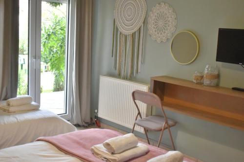 Zimmer mit 2 Betten, einem Stuhl und einem Spiegel in der Unterkunft Villa Gomfoi Trikala in Gómfoi