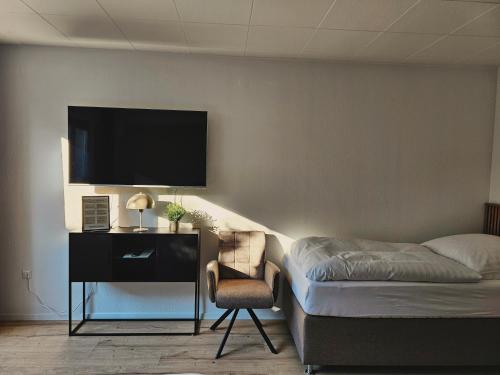 1 dormitorio con 1 cama, 1 silla y TV en Modern & Comfortable Apartment Stuttgart - Netflix - 4K TV - waipu en Korntal-Münchingen