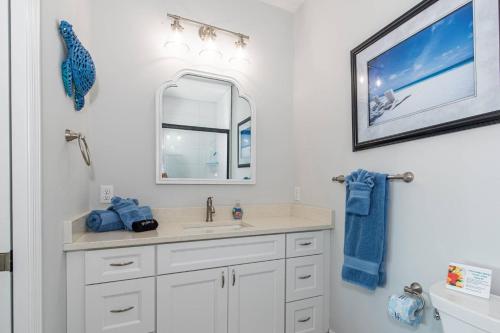 a bathroom with a sink and a mirror at Oceans 13 Condo D in Saint Augustine Beach