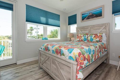 a bedroom with a bed and windows at Oceans 13 Condo D in Saint Augustine Beach