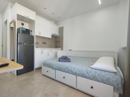a kitchen with a bed and a refrigerator at Apartamentos Bello Lanzarote in Arrecife