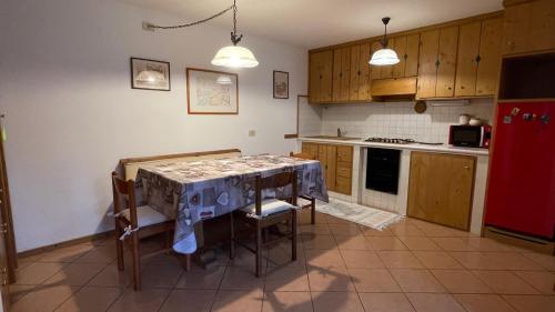 a kitchen with a table and chairs and a red refrigerator at Ciasa de Milu in Cibiana