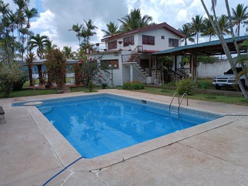a swimming pool in front of a house at Quinta El Espino in Ahuachapán