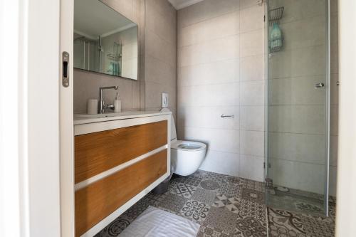y baño con aseo, lavabo y ducha. en Jaffas Yard By IsrApart, en Tel Aviv