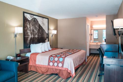 a hotel room with a large bed and a bathroom at Super 8 by Wyndham Columbia/Ft. Jackson SC in Columbia